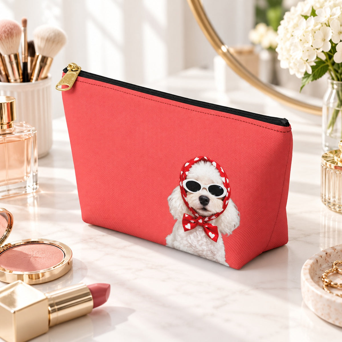 Red makeup pouch with a white Poodle in sunglasses and a red scarf angled view on a vanity