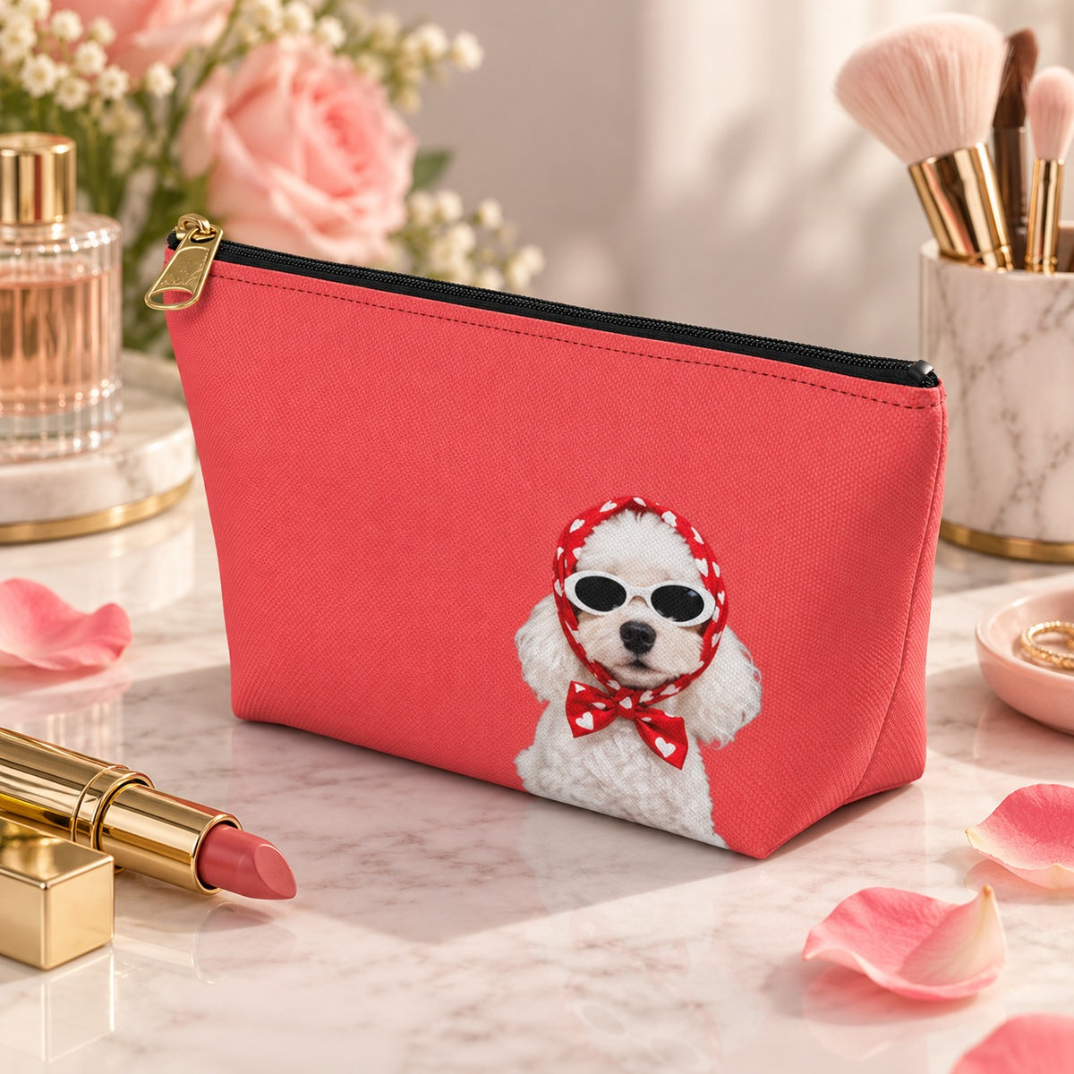 Red makeup pouch with a white Poodle in sunglasses and a red scarf beside flowers and perfume
