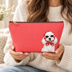 Red makeup pouch with a white Poodle in sunglasses and a red scarf held by a woman